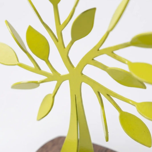 Detalles de escultura decorativa en forma de árbol metálico color amarillo limón sobre base de madera, diseñado por artist colombiano.