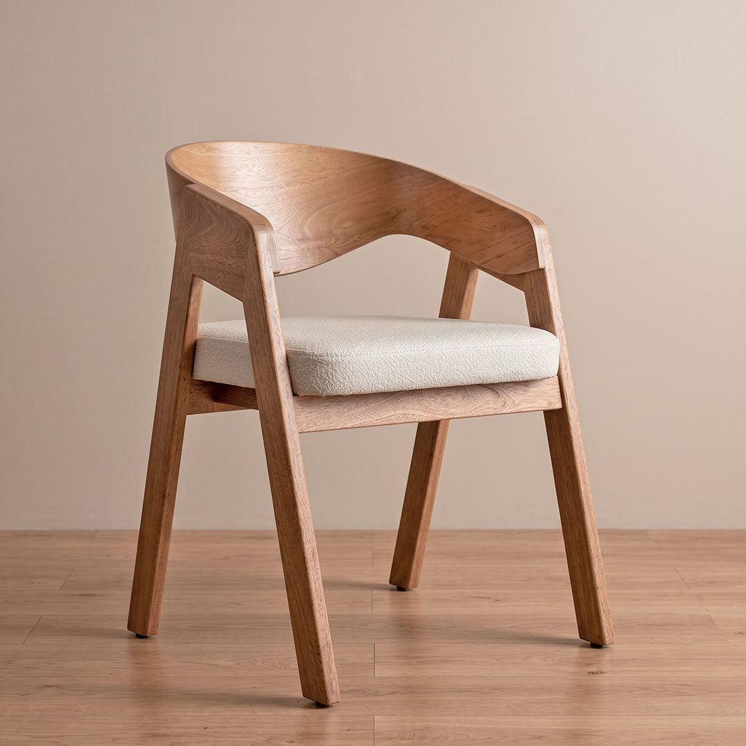 Silla de comedor Alfa en roble natural con asiento en bouclé crema, vista diagonal en ambiente cálido