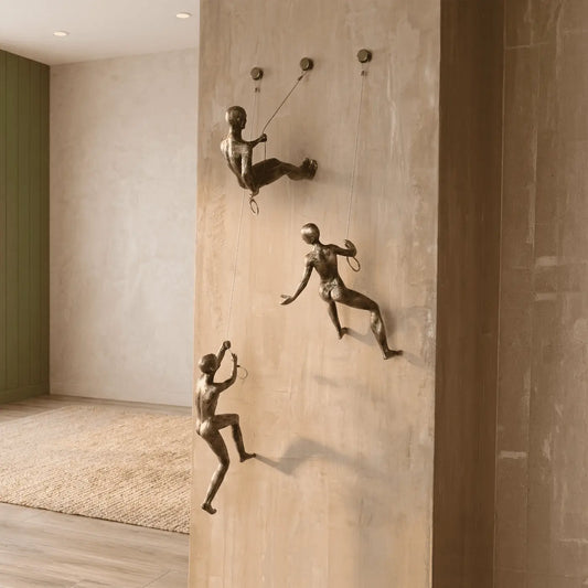 Decoración de pared con esculturas de escaladores en resina con acabado metálico en espacio moderno