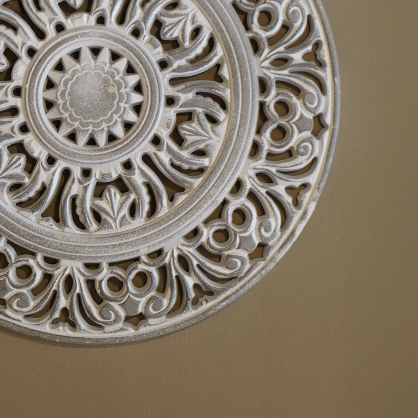 Primer plano del relieve y acabado artesanal de mandala de madera tallada para decoración de interiores.