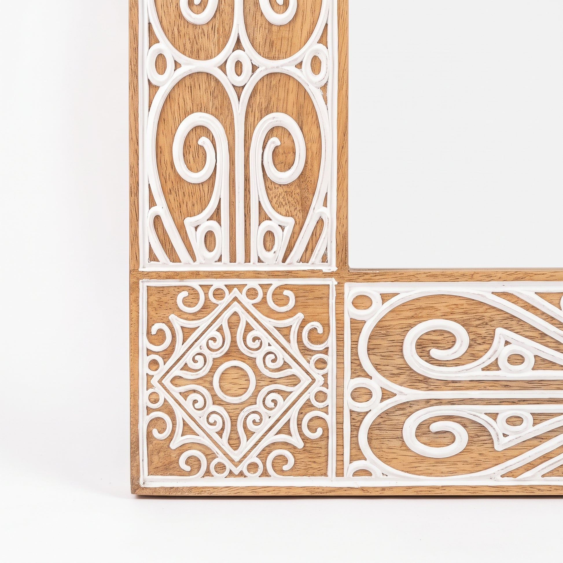 Detalle del tallado artesanal del Espejo Amazonas: motivos geométricos y espirales en relieve blanco sobre roble natural