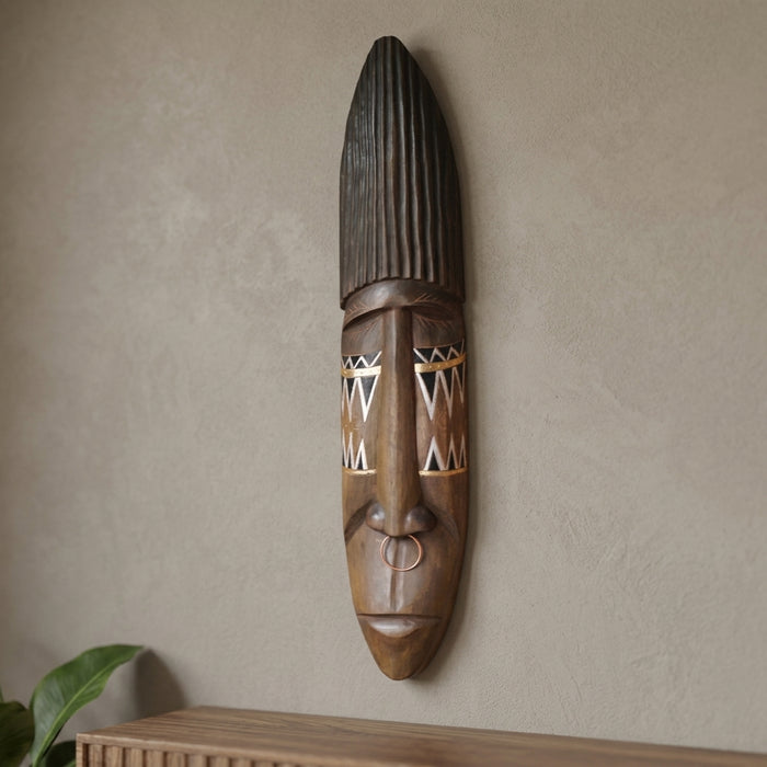 Máscara decorativa étnica tallada en corteza natural del Amazonas, colgada en pared sobre un mueble — Loft Mobiliario