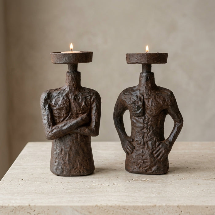 Portavelas de figura humana con brazos cruzados, en resina efecto oxidado, con vela tealight encendida en ambiente — Loft Mobiliario