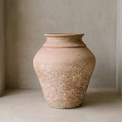 Macetera de barro artesanal con acabado terracota envejecido, en un rincón de muro encalado — Loft Mobiliario