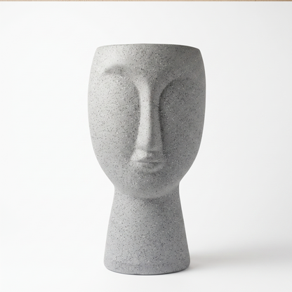 Matera decorativa con forma de rostro en cerámica gris moteado, vista frontal sobre fondo blanco
