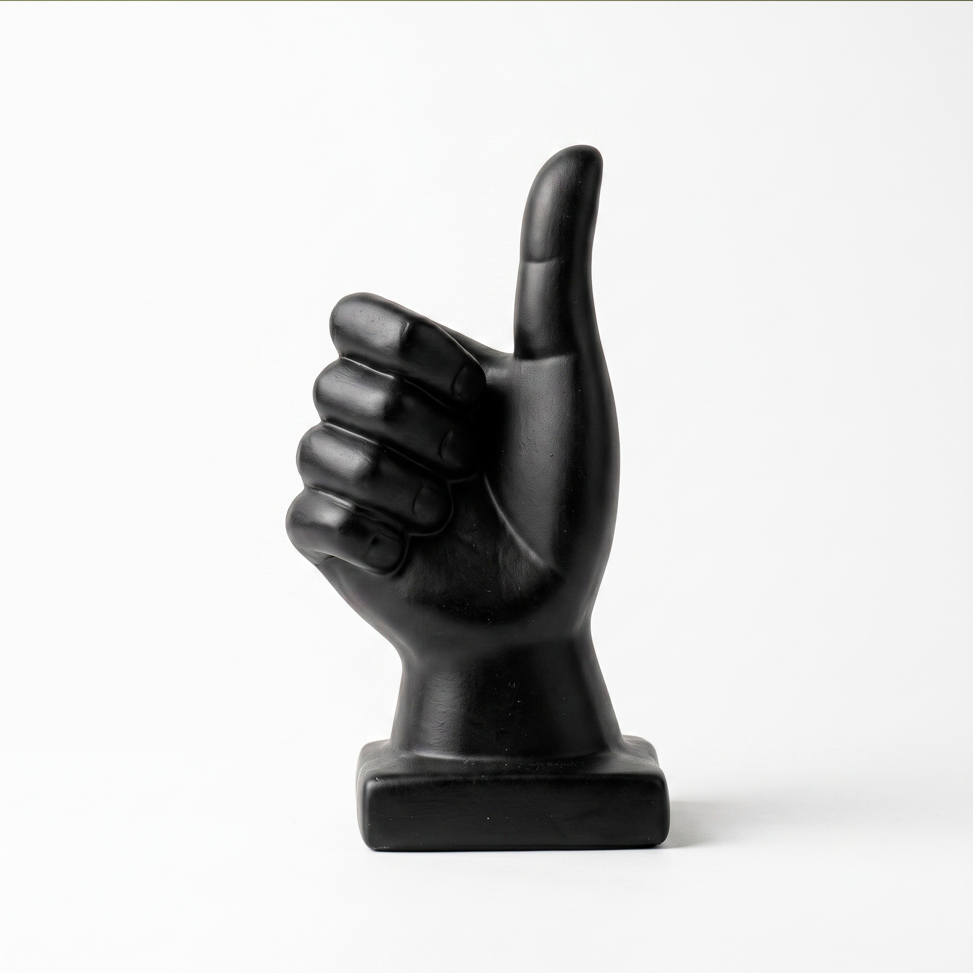 Escultura de mano pulgar arriba en cerámica negra mate, vista sobre fondo blanco