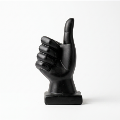 Escultura de mano pulgar arriba en cerámica negra mate, vista sobre fondo blanco