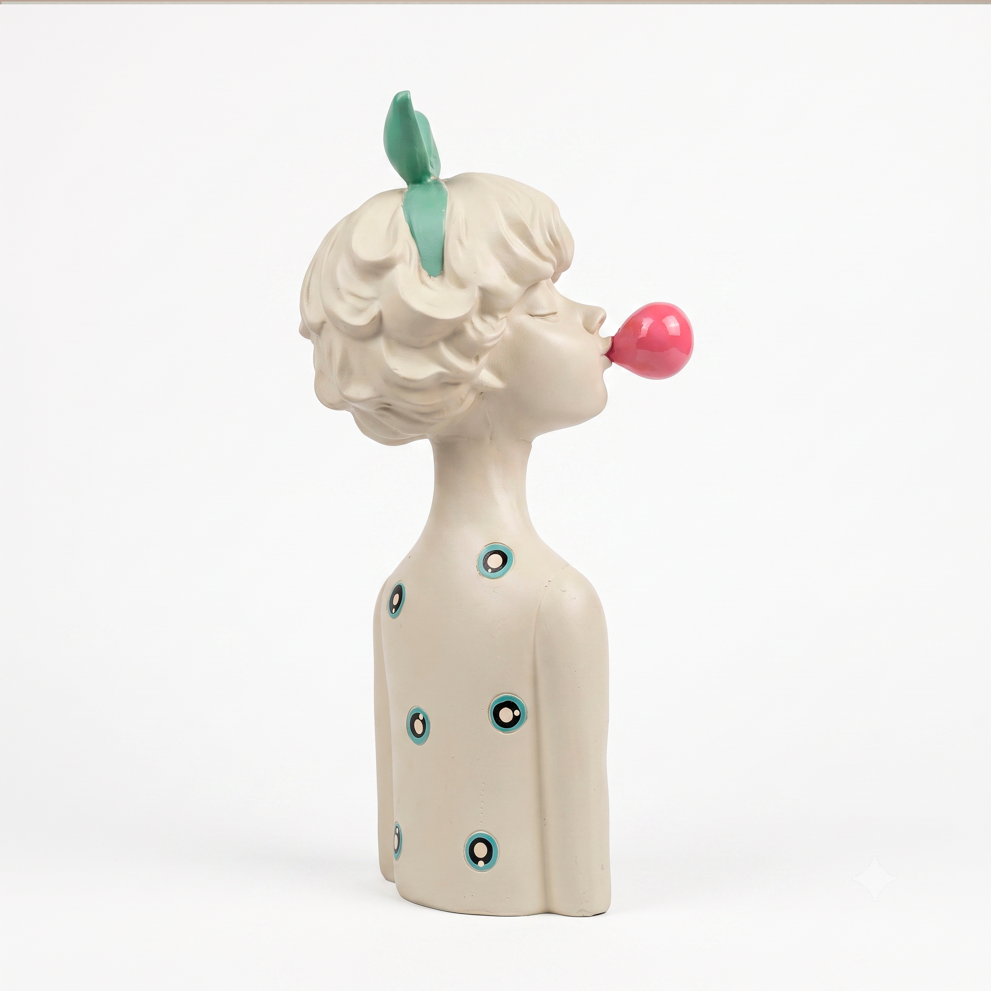 Figura decorativa niña con lazo agua marina y globo de chicle en resina blanca, sobre base de piedra travertino en ambiente neutro