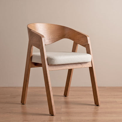 Silla de comedor Alfa en roble natural con asiento en bouclé crema, vista diagonal en ambiente cálido