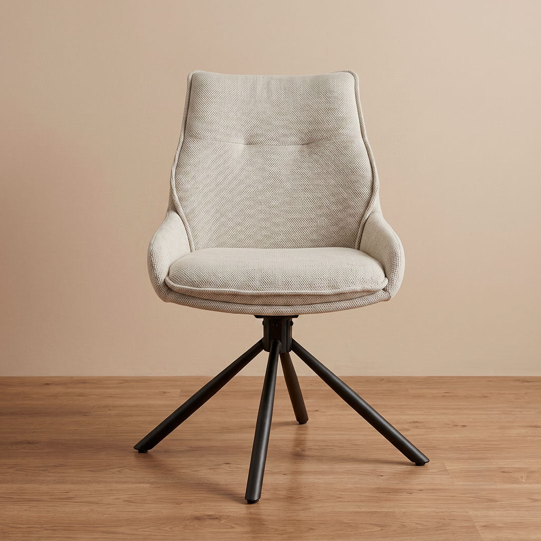 Detalle de la base metálica negra giratoria en aspa de la silla de comedor en lino beige