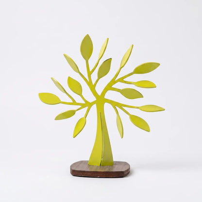 Escultura decorativa en forma de árbol metálico color amarillo limón sobre base de madera, diseño moderno de autor colombiano para decoración de interiores.