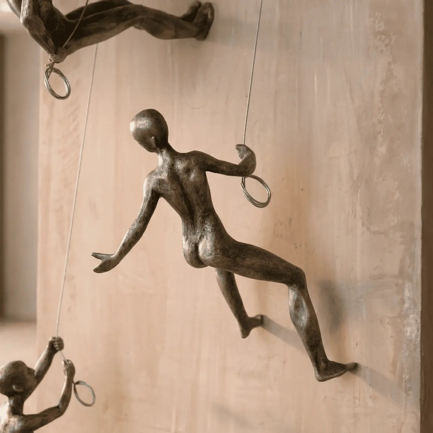 Detalle de escultura de escalador en resina con acabado metálico para decoración de pared