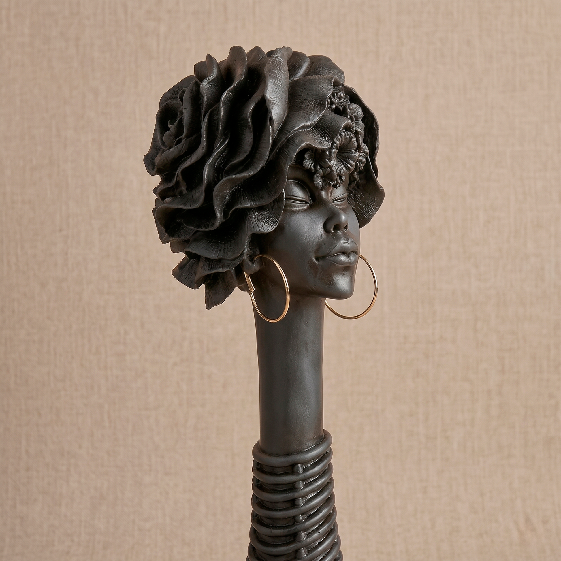 Escultura decorativa grande de resina negra con cuello anillado y aros dorados de Loft Mobiliario en Medellín.