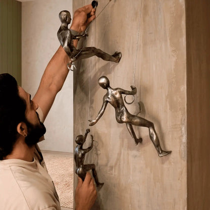 Instalación de esculturas de pared en resina con acabado metálico tipo escaladores para decoración moderna