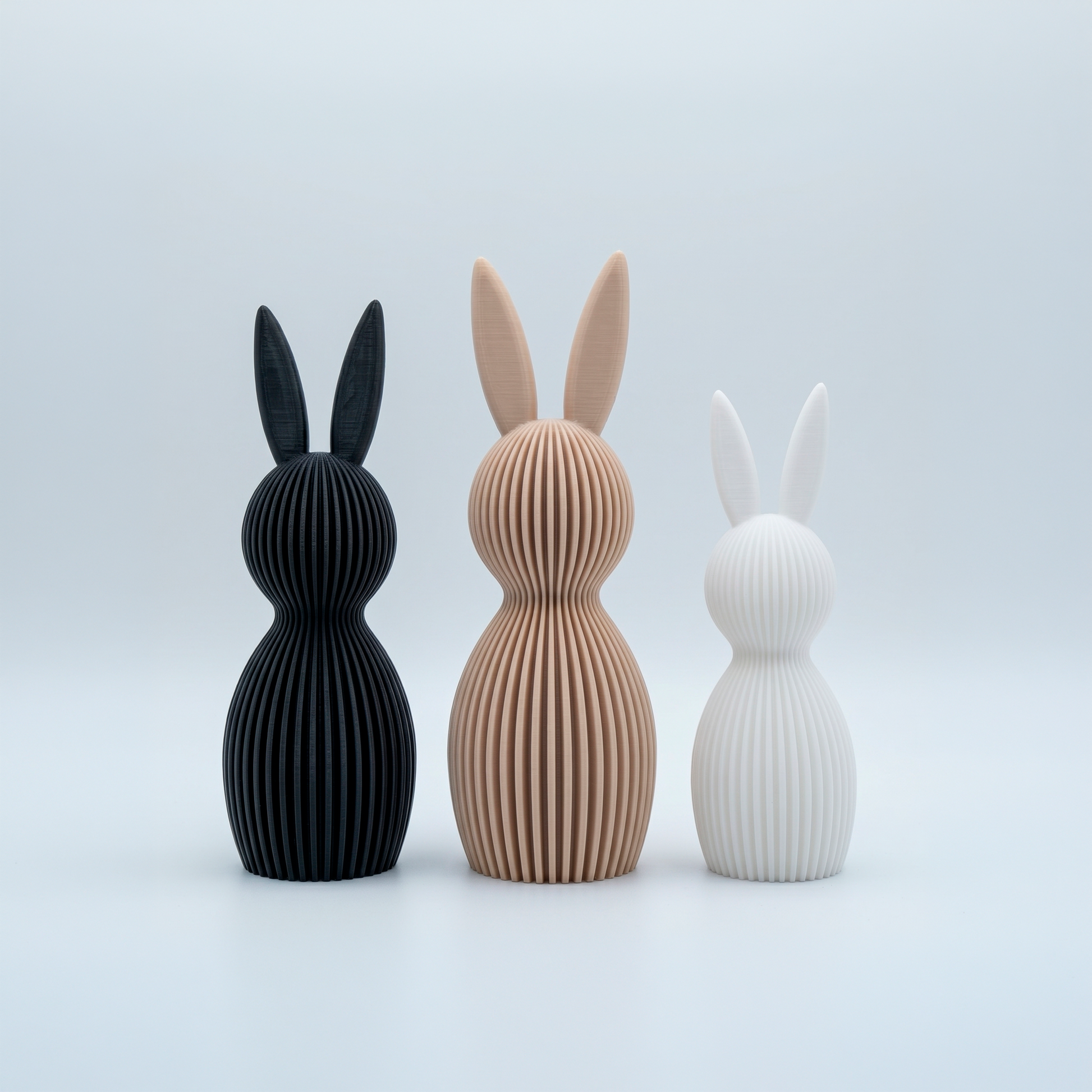 Set de tres figuras decorativas de conejos con textura de líneas en colores negro, arena y blanco de Loft Mobiliario en Medellín.