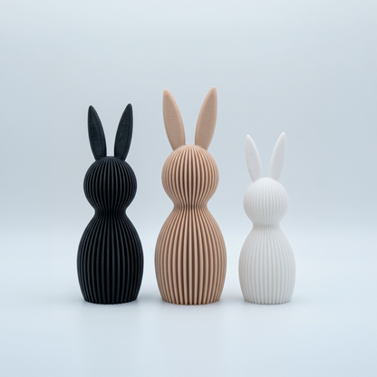 Set de tres figuras decorativas de conejos con textura de líneas en colores negro, arena y blanco de Loft Mobiliario en Medellín.
